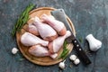 Raw uncooked chicken legs, drumsticks on wooden board, meat with ingredients for cooking Royalty Free Stock Photo