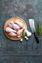 Raw uncooked chicken legs, drumsticks on wooden board, meat with ingredients for cooking Royalty Free Stock Photo