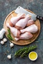 Raw uncooked chicken legs, drumsticks on wooden board, meat with ingredients for cooking Royalty Free Stock Photo