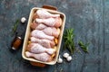 Raw uncooked chicken legs, drumsticks on wooden board, meat with ingredients for cooking Royalty Free Stock Photo