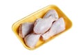 Raw and uncooked chicken legs with skin in a yellow plastic container. Fresh meat of poultry in tray, isolated on white background Royalty Free Stock Photo