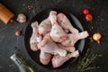 Raw uncooked chicken legs with spices and herbs in the black plate. Top view of chicken drumsticks Royalty Free Stock Photo