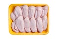 Raw and uncooked chicken wings in a yellow container. Meat of poultry in tray, isolated on white background. Top view Royalty Free Stock Photo