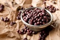 Raw, uncooked, dried adzuki red mung beans in small sieve on brown packing paper background