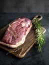 Raw uncooked duck breast with rosemary and thyme on wooden cutting board. Royalty Free Stock Photo