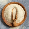 Raw uncooked fonio seeds with a spoon on a plate on grey background Royalty Free Stock Photo