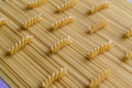 Raw fusilli pasta lies on spaghetti pasta