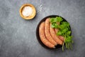 Raw uncooked meat sausages in a black iron pan. Royalty Free Stock Photo