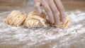 Raw uncooked past and fettuccine with flour on wooden table, close up shot