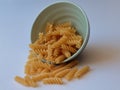 Raw uncooked pasta fusulli in ceramic bowl over white background