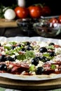 Raw uncooked pizza with pepperoni salami, black olives, basil and cheese Royalty Free Stock Photo