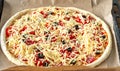 raw uncooked pizza pie with pepperoni  tomatoes  black olives and mozzarella on baking tray Royalty Free Stock Photo