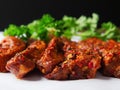 Raw uncooked pork belly slices marinated with Korean style souse and herbs and fresh coriander leafs on a white surface, Meat