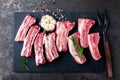 Raw uncooked pork ribs, fresh meat on dark metal background. Top view Royalty Free Stock Photo