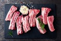 Raw uncooked pork ribs, fresh meat on dark metal background. Top view Royalty Free Stock Photo