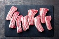 Raw uncooked pork ribs, fresh meat on dark metal background. Top view Royalty Free Stock Photo