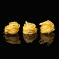 Raw uncooked tagliatelle nests on black background with reflection. Traditional Italian pasta Royalty Free Stock Photo