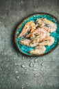 Raw uncooked tiger prawns on chipped ice, grey concrete background Royalty Free Stock Photo