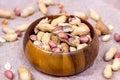 Raw unpeeled peanut nuts in nutshell in brown round wooden bowl on light paper background. Royalty Free Stock Photo