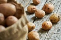 Raw potatoes on the rough wooden boards and a burlap sack Royalty Free Stock Photo