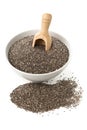 Raw, unprocessed, dried black chia seeds in white bowl with wood