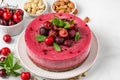 Raw vegan cheesecake with fresh cherries and mint on white background. close up with copy space Royalty Free Stock Photo