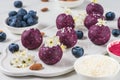 Raw vegan energy bites or balls made of blueberry, acai, nuts and dates served with flowers. Food styling