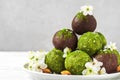 Raw vegan homemade green matcha dessert with matcha energy balls in chocolate glaze and spring flowers Royalty Free Stock Photo