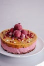 Raw vegan raspberry cake decorated with berry truffles. Mango filling jelly vegetarian cashew cream cheesecake gluten