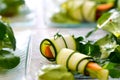 Raw vegan rolls with radish, cucumber, fine herbs, parsley and carrots on glass plate