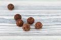 Raw vegan sweets, energy balls with dried fruits, coconut and carob powder. Vegetarian round candies on light wooden table. Royalty Free Stock Photo