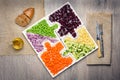 Vegan salad in the form of jigsaw puzzles from plates with different vegetaStill life of fresh vegetables for a megan salad salad. Royalty Free Stock Photo