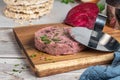 Raw veggie burger with beetroot and white beans with parsley leaves on wood cutting board Royalty Free Stock Photo