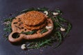 Raw veggie burger on wood and black background with pumpkin seeds, arugula leaves, cashew and sesame seeds. inviting nutritious Royalty Free Stock Photo