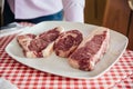 Raw wagyu beef cuts from left to right: T-Bone Steak, Rib Eye and Boneless Top Loin Steak. Royalty Free Stock Photo