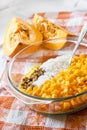 Raw washed millet, rice, raisins and pumpkin in a glass pan in the process of cooking milk pumpkin porridge Royalty Free Stock Photo