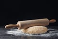 Raw wheat dough with flour and rolling pin