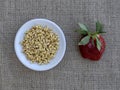 Raw wheat germ and strawberry on burlap fabric Royalty Free Stock Photo