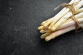 Raw white fresh asparagus on a black stone background. Healthy food. Top view. Free space for your text Royalty Free Stock Photo