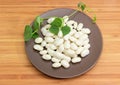 Raw white kidney beans on brown dish with bean stem