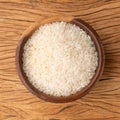 Raw white rice in a bowl over wooden table Royalty Free Stock Photo