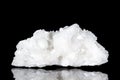 Raw white stilbite or desmine mineral stone in front of black background