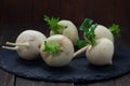 Raw white turnips on wooden board