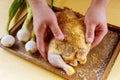 raw whole chicken with colorful pieces of peppers, rosemary leaves in the baking dish, preparing for roast