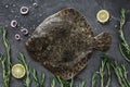 Raw whole flounder fish with rosemary on dark stone background. Creative layout made of fish, top view