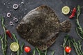 Raw whole flounder fish with rosemary, onions and spices on dark stone background. Creative layout made of fish, top view.