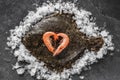 Raw whole flounder fish with shrimps stacked as a heart on ice over dark stone background. Creative layout made of fish, top view Royalty Free Stock Photo