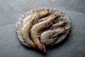 Raw whole fresh uncooked prawns shrimps on stone gray plate, stone background. Top view with copy space