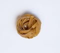 Raw whole grain brown pasta Tagliatelle on a white background Royalty Free Stock Photo