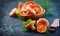 Raw wild Saffron milk cap mushrooms on dark old rustic background. Lactarius deliciosus, Rovellons, Niscalos mushroom closeup Royalty Free Stock Photo